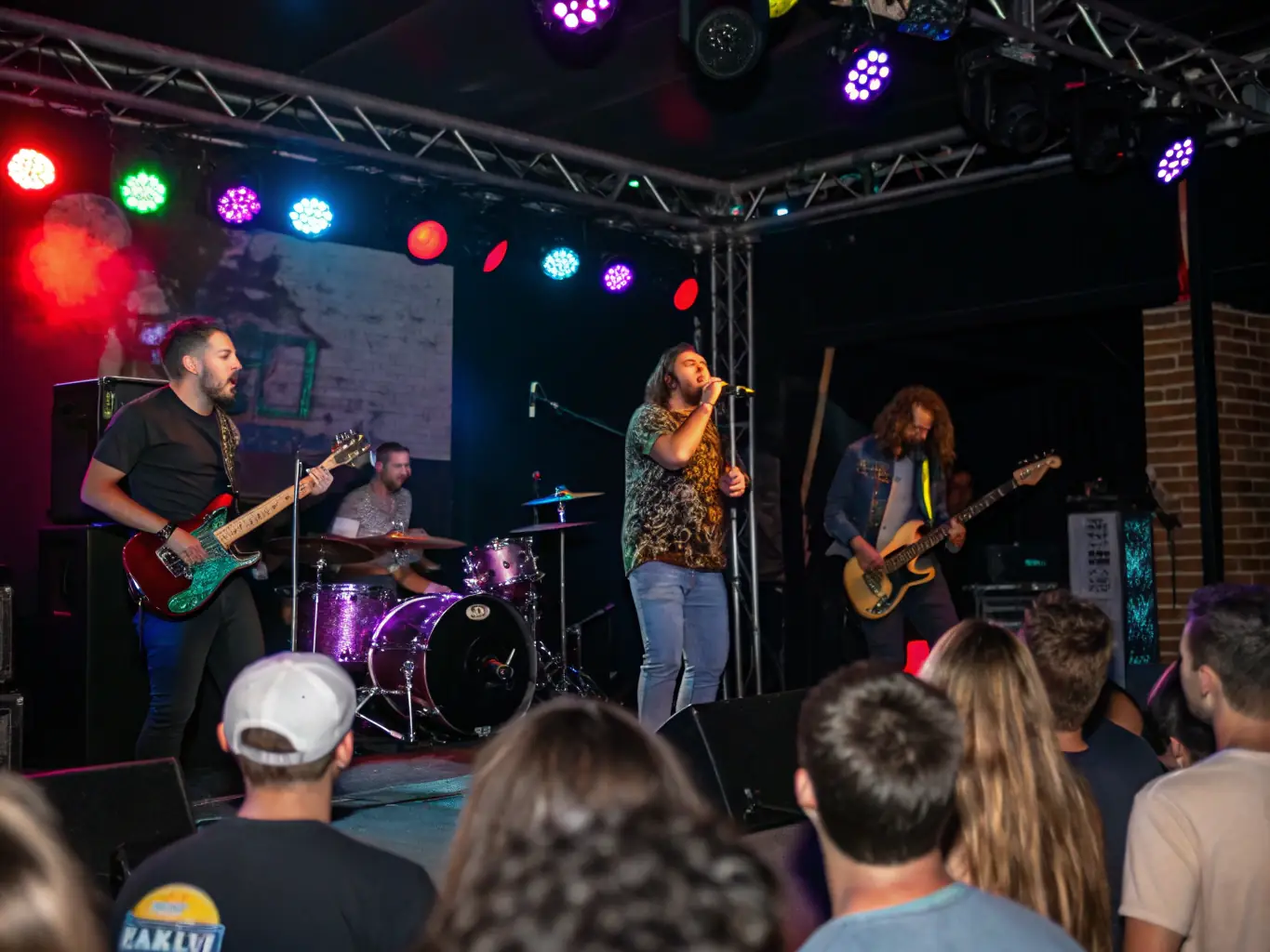 A dynamic scene of a live performance organized by RESONANCES PLURIELLES, featuring musicians and performers on stage, with an enthusiastic audience.